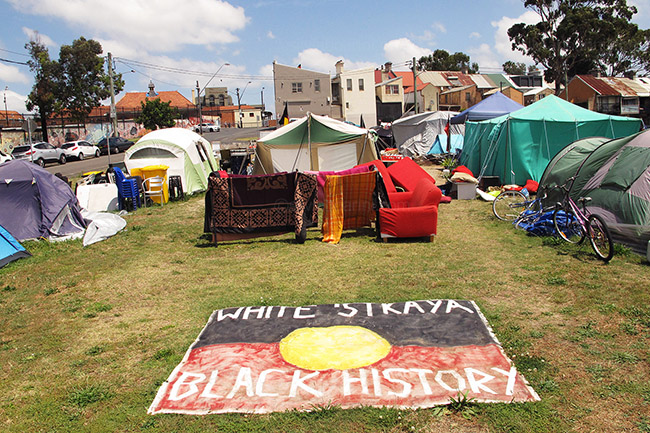 A flag in the middle of the camp reads 'white Australia has black history'. Redfern, Australia. 4/11/2014